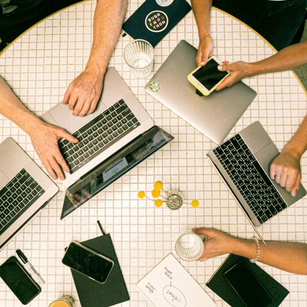 pexels-photo-3194519-3194519 Top view of a team collaborating with laptops, phones, and notes in a modern office.